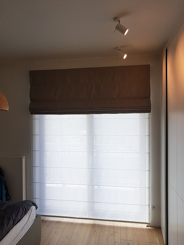 biało czarna roleta rzymska w sypialni